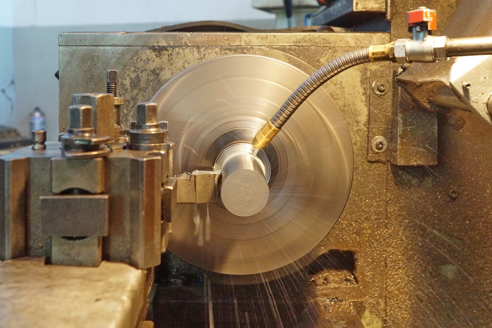 Round steel workpiece being turned on a CNC lathe